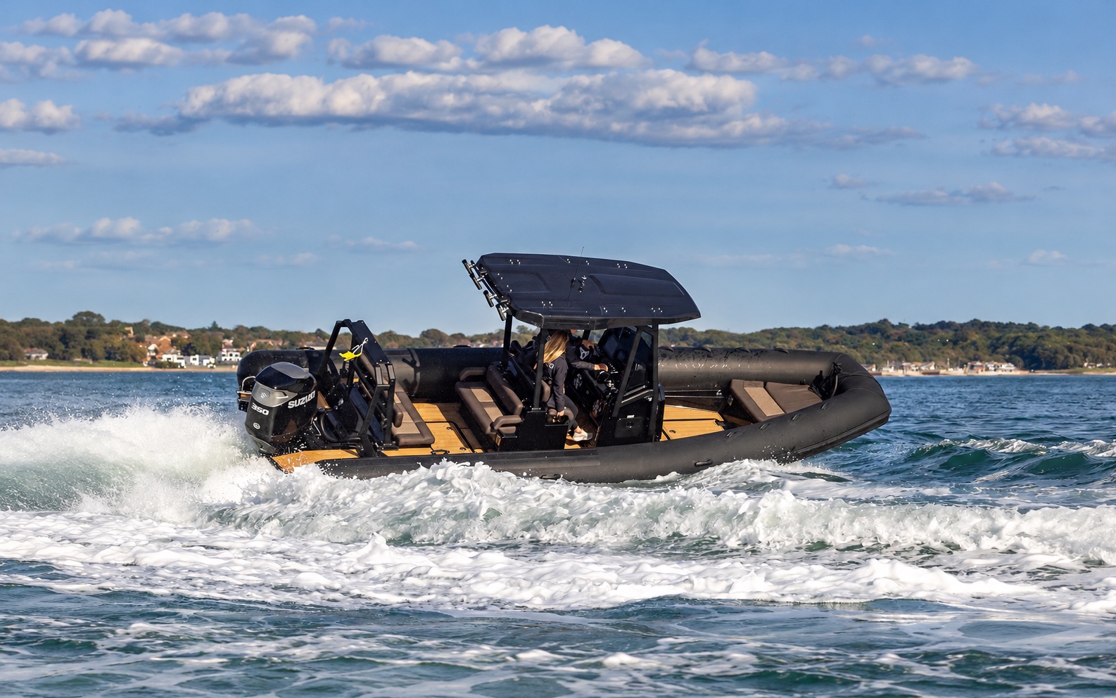Black rigid inflatable boat underway on the Exe Estuary